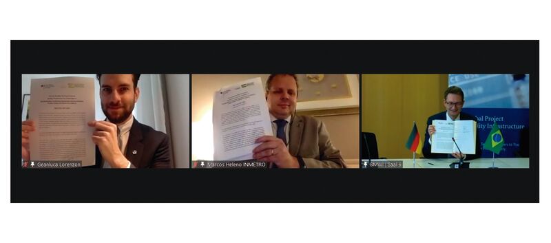 Geanluca Lorenzon (ME), Marcos Heleno (Inmetro) und Stefan Schnorr (BMWi) halten den Arbeitsplan 2021-2022 in die Kamera.